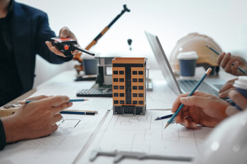 Skilled team of engineers collaborates in meetings, drafting blueprints for condos, apartments,...