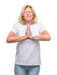 Obraz premium Middle age blonde woman over isolated background begging and praying with hands together with hope expression on face very emotional and worried. Asking for forgiveness. Religion concept.