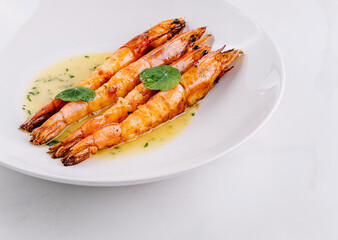 Grilled shrimp with garlic sauce on white plate