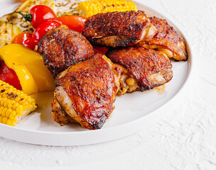 Grilled chicken thighs with vegetables on plate