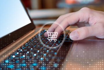 Hand typing on laptop with shopping cart icons. Concept of online shopping. Seamless online...