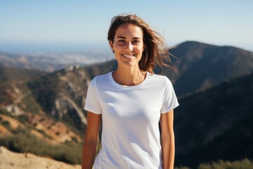 Portrait of a happy woman in her 30s dressed in a casual t-shirt on panoramic mountain vista