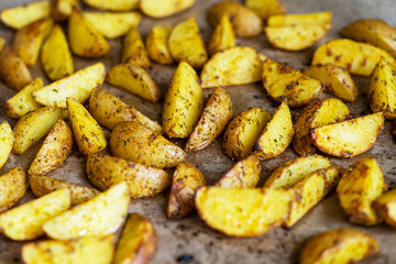 Appetizing baked potato slices with spices, close up
