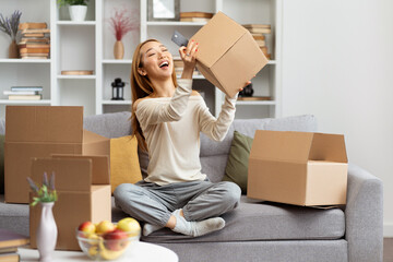 Joyful Woman Unboxing In Living Room Captures Selfie, Expressing Happiness And Excitement, Home...