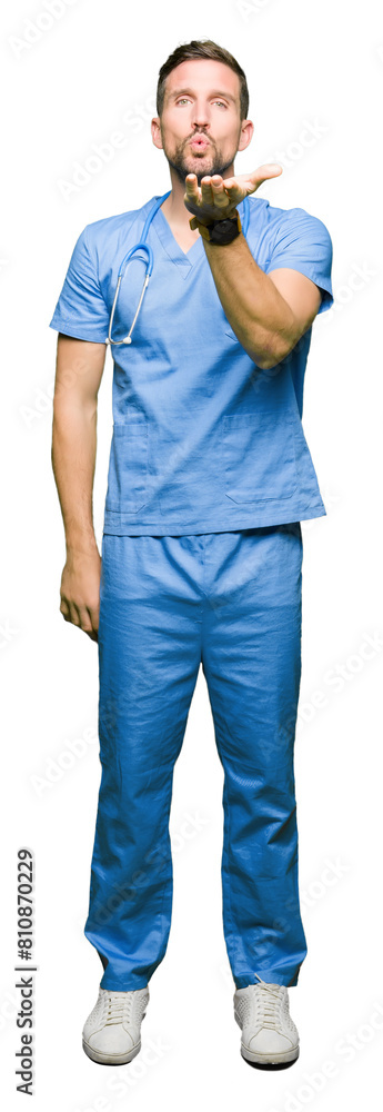 Canvas Prints handsome doctor man wearing medical uniform over isolated background looking at the camera blowing a