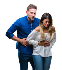 Obraz premium Young couple in love over isolated background with hand on stomach because indigestion, painful illness feeling unwell. Ache concept.