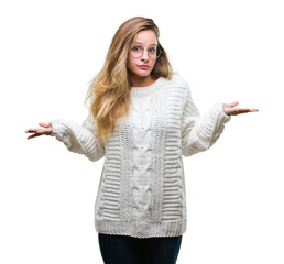 Young beautiful blonde woman wearing winter sweater and sunglasses over isolated background...