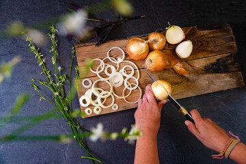 Cebollas marrones y rodajas sobre tabla de cortar de madera. Fondo de alimentos saludables.