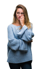 Young beautiful blonde woman wearing sweater and glasses over isolated background looking stressed and nervous with hands on mouth biting nails. Anxiety problem.