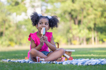 Pretty kid girl eating ice cream, Child girl playing outdoors in the garden