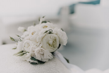 A bouquet of white flowers is sitting on a white surface. The flowers are arranged in a way that...