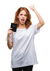 Fototapeta premium Young beautiful woman holding passport of australia over isolated background annoyed and frustrated shouting with anger, crazy and yelling with raised hand, anger concept