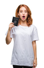 Fototapeta premium Young beautiful woman holding passport of italy over isolated background scared in shock with a surprise face, afraid and excited with fear expression