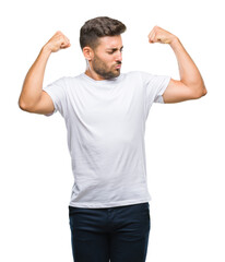 Young handsome man over isolated background showing arms muscles smiling proud. Fitness concept.