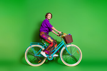 Profile photo of happy young woman wear purple shirt bob haircut riding bike in spring season...