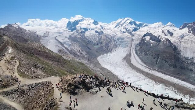 Flight towards the observatory at Gornergrat, Swiss Alps mountains in, Zermatt, Switzerland with the reveal view of a beautiful glacier getting shorter due to climate change/global warming.