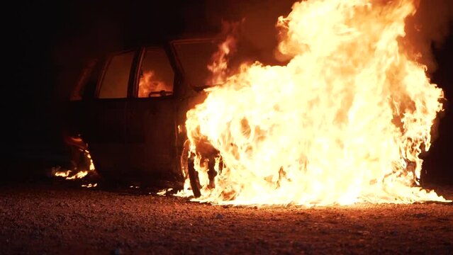 Burning car close to a house in the city of slow motion. Theme of criminal revenge and set fire to someone else car. Automobile engulfed in flames of fire. High quality 4k footage
