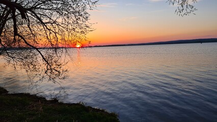 Lake with trees at sunset on a beautiful summer evening
