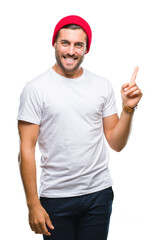 Young handsome man over isolated background with a big smile on face, pointing with hand and finger to the side looking at the camera.