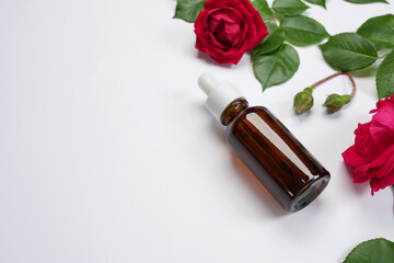 Product for skincare based on rose oil, essential oil solution in dropper bottle. Brown pipette...