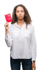 Young hispanic woman holding passport of Switzerland with a confident expression on smart face thinking serious