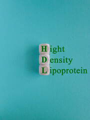 HDL - High-density lipoprotein acronym with marker. Concept words HDL - High-density lipoprotein on beautiful wooden cubes. Beautiful blue background. Health concept.