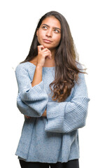 Young beautiful arab woman wearing winter sweater over isolated background with hand on chin thinking about question, pensive expression. Smiling with thoughtful face. Doubt concept.