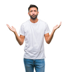 Adult hispanic man over isolated background clueless and confused expression with arms and hands raised. Doubt concept.