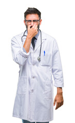 Adult hispanic doctor man over isolated background smelling something stinky and disgusting, intolerable smell, holding breath with fingers on nose. Bad smells concept.
