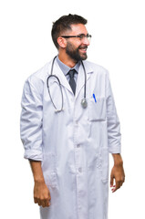 Adult hispanic doctor man over isolated background looking away to side with smile on face, natural expression. Laughing confident.