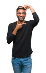 Fototapeta premium Adult hispanic man wearing glasses over isolated background smiling making frame with hands and fingers with happy face. Creativity and photography concept.