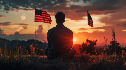 Man sitting in contemplation under USA flags at sunset on National Day of Prayer