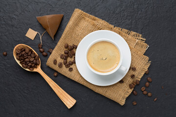 Cup of coffee made using pyramid on concrete background, top view