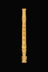 Folk wooden recorder on a black background.
