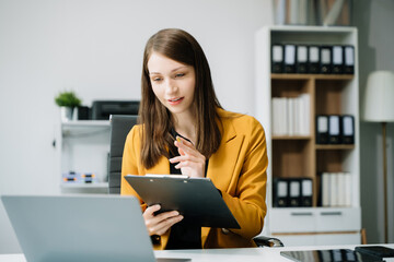 Business woman sitting at a desk using a laptop computer Navigating Finance and Marketing with Technology