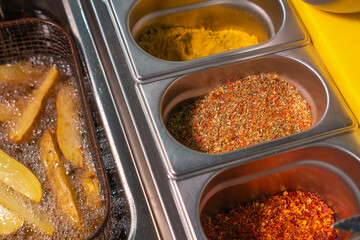 Close-up of a variety of colorful spices in open containers in restaurant kitchen, selective focus