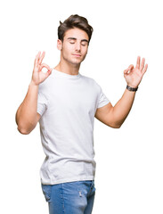 Fototapeta premium Young handsome man wearing white t-shirt over isolated background relax and smiling with eyes closed doing meditation gesture with fingers. Yoga concept.
