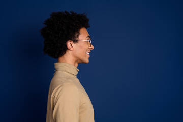 Photo portrait of attractive young man profile look empty space dressed stylish beige clothes isolated on dark blue color background