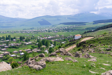 View of village, small white church and mountains. Ktsia, Avranlo, Georgia