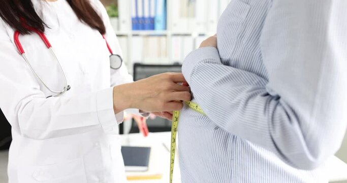 Doctor obstetrician-gynecologist measuring volume of abdomen of pregnant woman using centimeter tape 4k movie. Medical supervision of pregnant women concept
