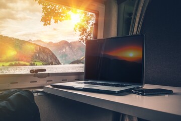 Laptop Computer on a Camper Table with Scenic Fjords View, concept of work while traveling