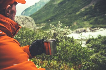 Caucasian Hiker Enjoying Hot Tea and the Vista on the Mountain Trail