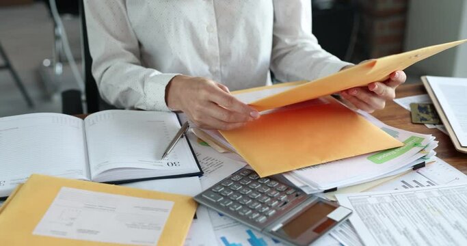 Female secretary sorting postal letters at table in office closeup 4k movie. Secretarial profession concept