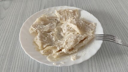 Plate of boiled dumplings with sour cream