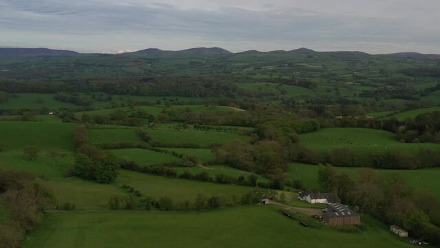 Aerial view of farm fields with hedge rows and trees landscape of England and Wales taken from drone UK 4K