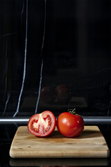 tomato open on a wooden board with a beautiful black worktop.