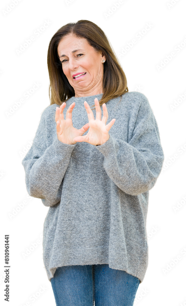 Poster Beautiful middle age woman wearing winter sweater over isolated background disgusted expression, displeased and fearful doing disgust face because aversion reaction. With hands raised.