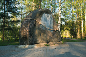 A huge, flat stone, tied with a rope