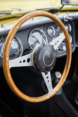 An old vintage car steering wheel and dashboard. Detail of the interior of a classic vehicle....