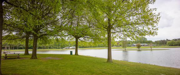 Public water park with small beach wide angle panorama landscape of recreational pond Lageveld in Wierden with picnic field and leisure area